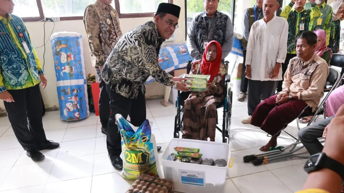 SOSIAL:Bupati HSU, H Sahrujani menyerahkan bantuan ATENSI kepada penerima manfaat penyandang disabilitas dalam rangka bakti sosial dan syukuran kantor baru Dinas Sosial HSU, Kamis (4/6/2026).(Foto: Pemkab HSU)