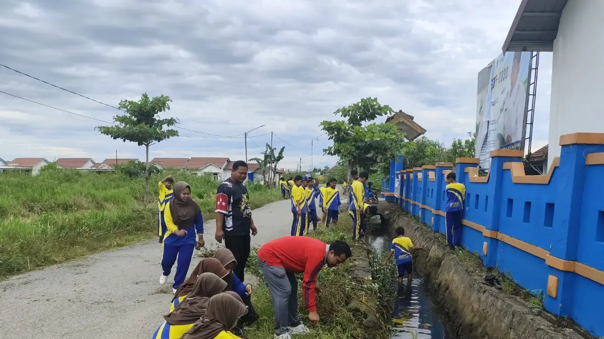 BERSIHKAN LINGKUNGAN: Siswa dan guru SMPN 5 Simpang Empat membersihkan saluran drainase di sekitar sekolah dalam kegiatan Jumat Bersih sebagai bagian dari program menuju Adiwiyata Nasional, Jumat (29/5/2026).
