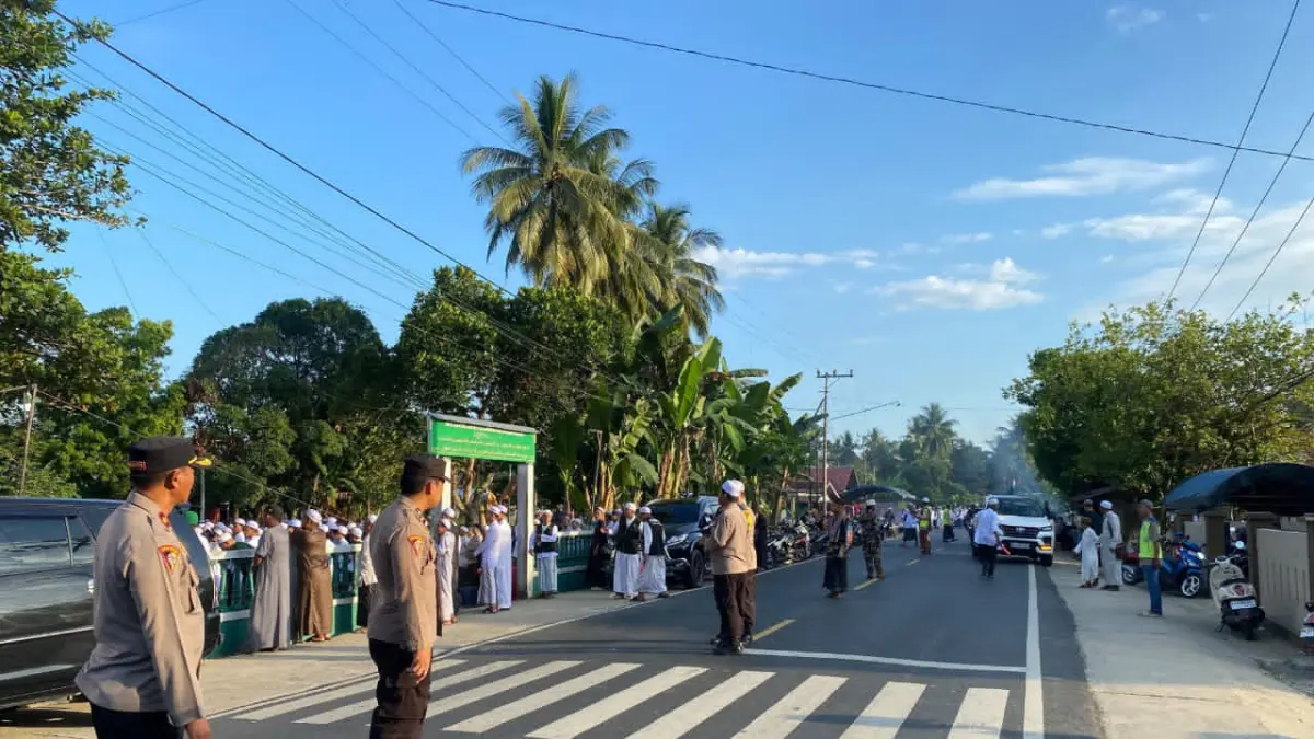 SIAGA: Polisi melakukan pengamanan di depan makam KH Mahfuz Amin di Desa Pamangkih, Minggu (7/6/2026).(Foto: Polres HST)