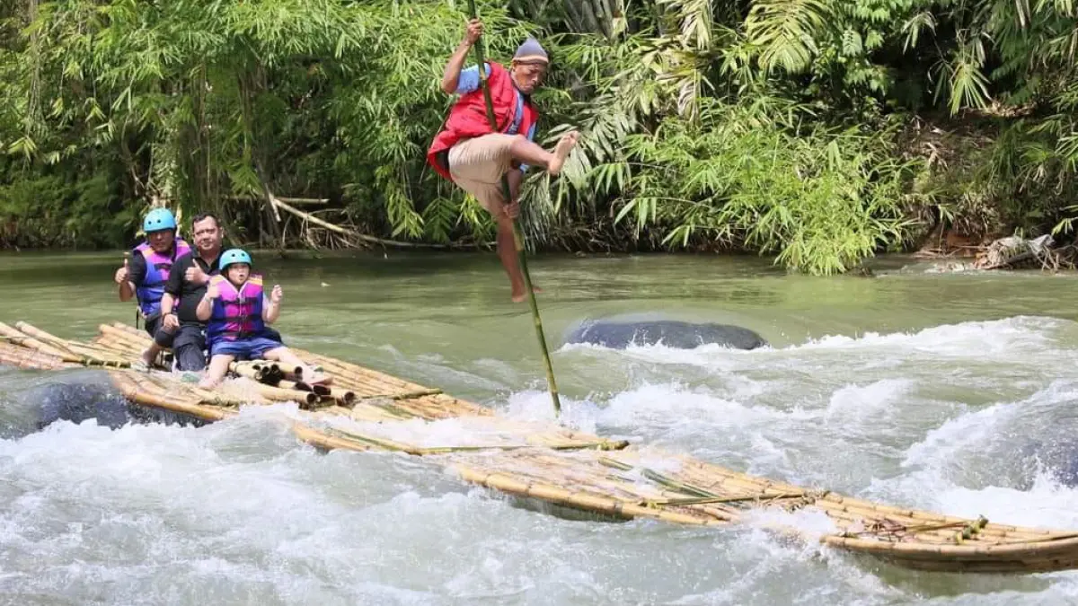 ATRAKSI: Joki Bamboo Rafting saat lakukan atraksi di atas lanting.