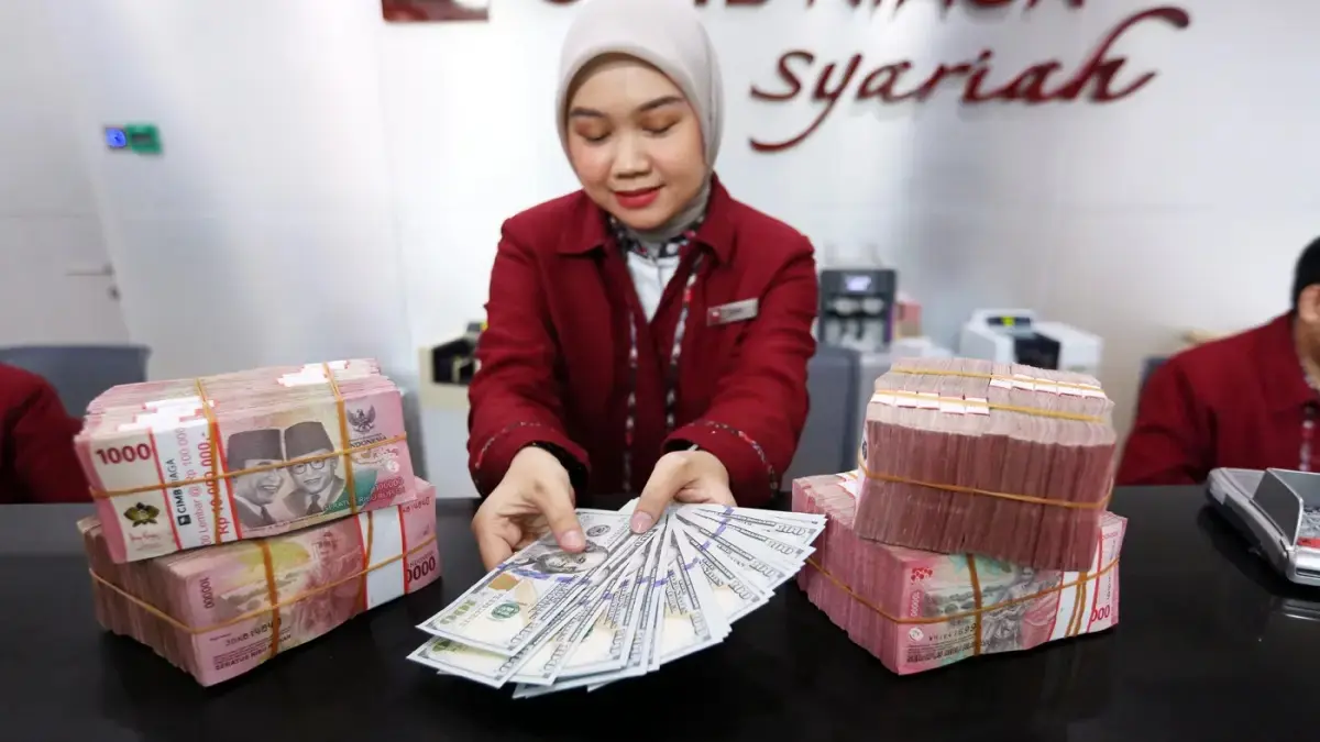 PELEMAHAN RUPIAH: Karyawan menunjukkan uang rupiah dan dolar Ameria Serikat di gerai penukaran mata uang asing di Jakarta. (Dery Ridwansyah/Jawa Pos)