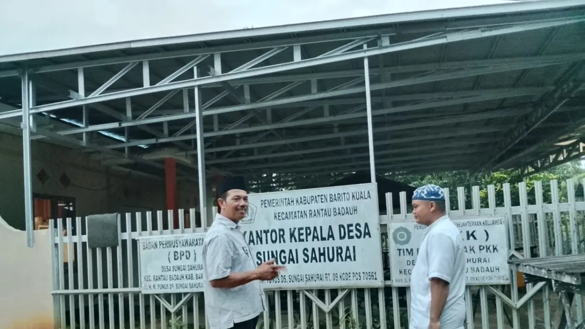Teks Foto: KANTOR DESA: Kepala Desa Sungai Sahurai, Husaini bersama warga di depan kantor desa yang berada tak jauh dari Jalan Raya H. M Yunus, Batola.