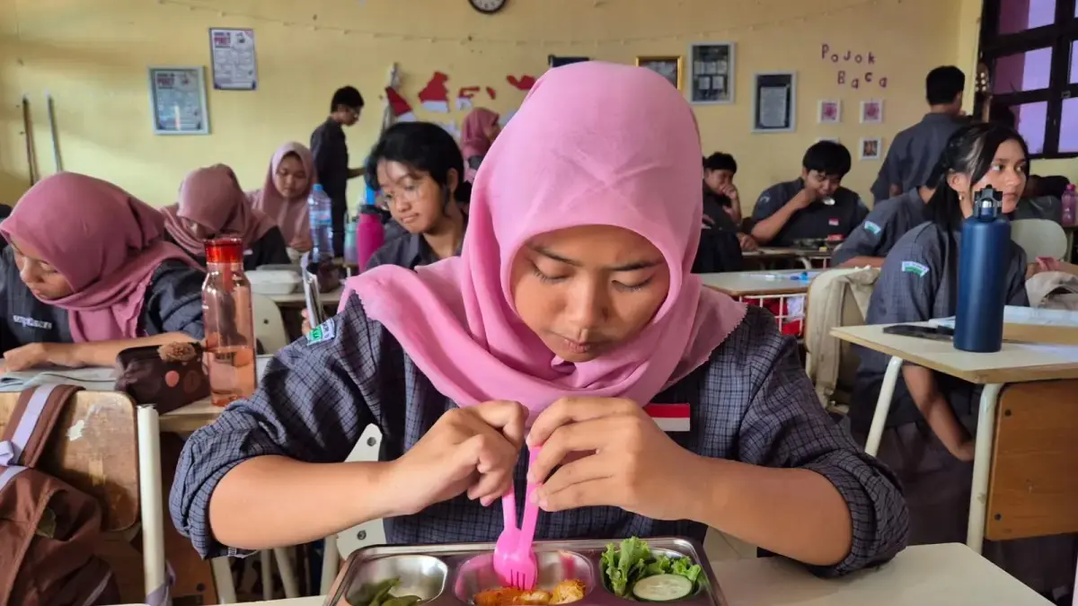 Teks foto: AKAN DIRECOFUSING: Siswa SMA Negeri 10 Surabaya sedang menyantap menu Makan Bergizi Gratis (MBG). (Novia Herawati/Jawa Pos)