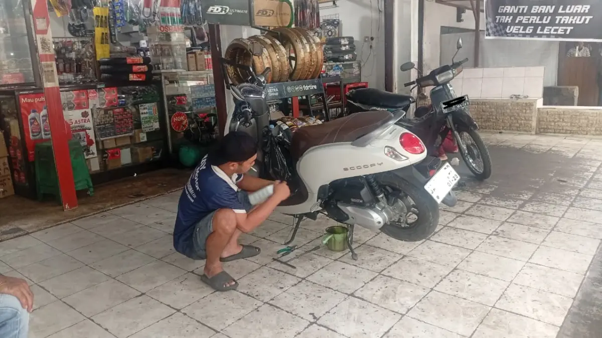 GANTI OLI: Montir saat menggantikan oli kendaraan di Kandangan.