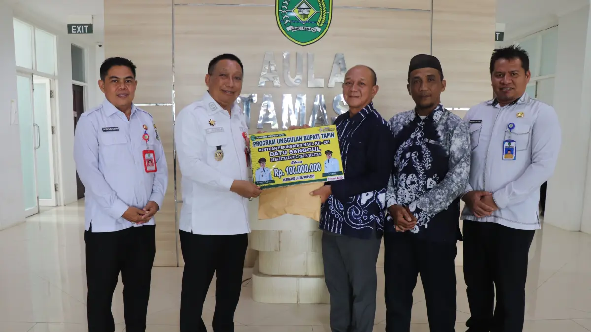 MENERIMA BANTUAN: Kepala Desa Tatakan Ilhamsyah menerima bantuan secara simbolis dari Pemerintah Daerah untuk haul Datu Sanggul, diserahkan Wakil Bupati Tapin H Juanda.
Foto Prokopim Setda Tapin&nbsp;
