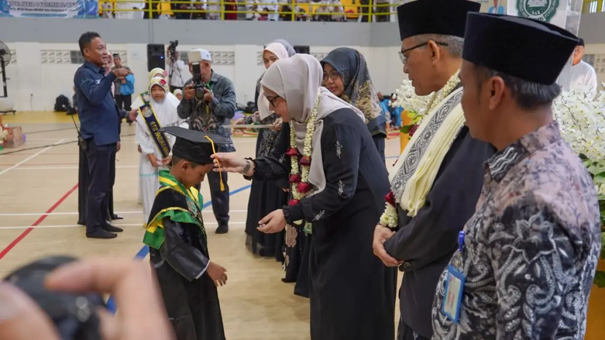 LULUS: Wali Kota Banjarbaru, Lisa Halaby menyematkan tanda kelulusan pada salah satu santri BKPAKSI di GOR Babussalam, Sabtu (13/6/2026).(Foto: MC Banjarbaru)