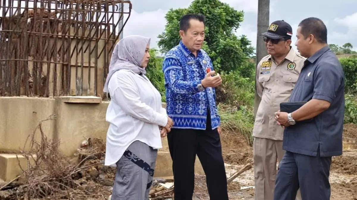 MULAI DIKERJAKAN: Anggota Komisi III DPRD Tanah Bumbu, Masripay (baju hitam), meninjau pembangunan jembatan penghubung Satui Barat–Desa Jombang di Batulaki, Kecamatan Satui. (Foto: Masripay untuk Radar Banjarmasin)