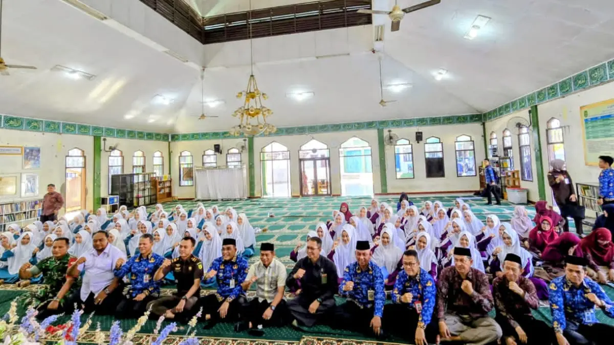 MOMEN: Bupati HSU, H Syahrujani (lima dari kiri) saat foto bersama dengan peserta dan narasumber lainnya memberikan sosialisasi bahaya radikalisme serta pencegahan dan pemberantasan penyalahgunaan narkoba kepada puluhan santriwati Ponpes Rakha Amuntai, Rabu (17/6/2026). (Foto: M Akbar/Radar Banjarmasin)