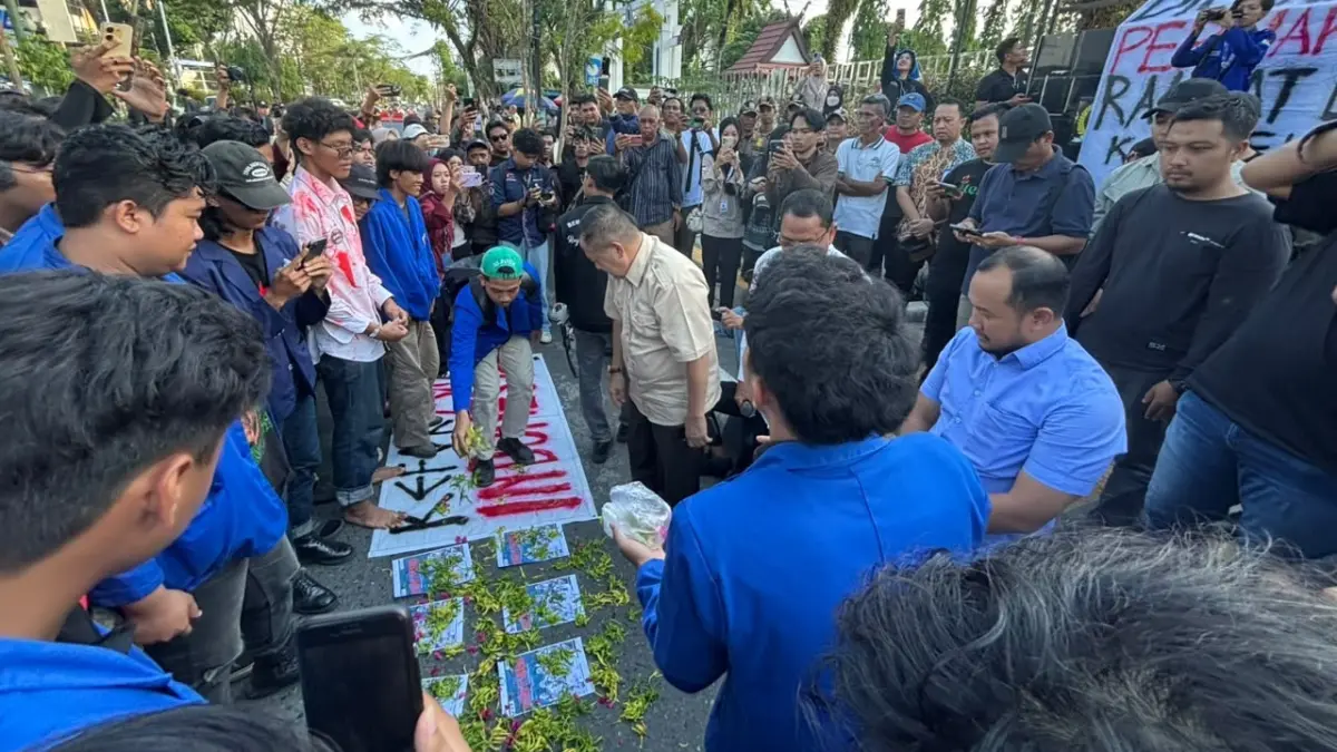 TABUR BUNGA: Gambar 11 wajah anggota DPR RI dapil Kalsel ditaburi bunga sebagai bentuk simbolik yang berlangsung saat unjuk rasa di depan Kantor DPRD Kalsel, Jalan Lambung Mangkurat, Banjarmasin. (Zulvan Rahmatan/Radar Banjarmasin)
