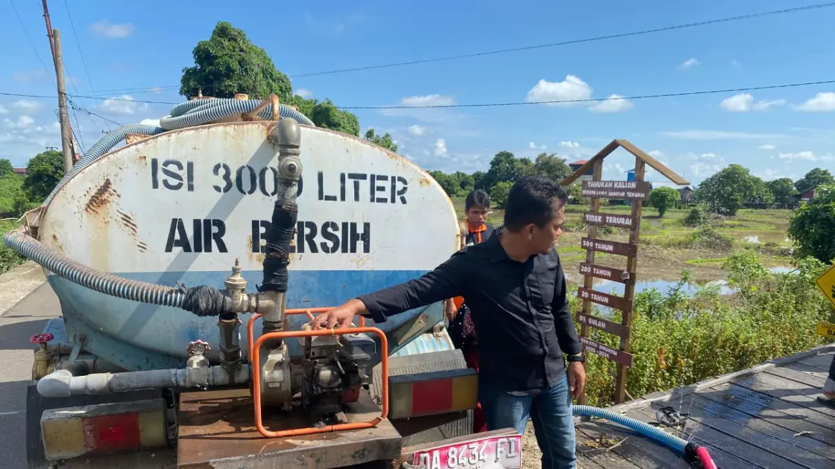 HADIR: Kapolsek Banjang AKP Robby Ansharie Bahasuan bersama aparat desa saat menyalurkan bantuan 3.000 liter air bersih dari Polres HSU kepada warga Desa Danau Terate, Kecamatan Banjang. (Foto: Istimewa)