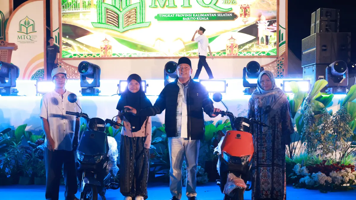 BERUNTUNG: Bupati Kabupaten Barito Kuala, H Bahrul Ilmi menyerahkan hadiah sepeda listrik kepada Mislawati di ajang MTQ Nasional XXXVII Kalsel 2026 di Marabahan.(Foto: Prokopim Batola)&nbsp;