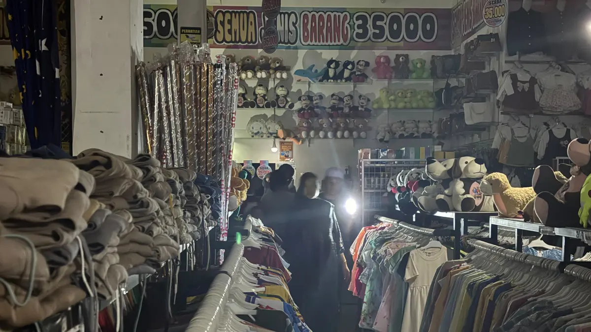 Pengunjung salah satu toko ritel di Jalan Trans Kalimantan, Handil Bakti, Kabupaten Barito Kuala menggunakan senter pribadi untuk melihat pakaian akibat pemadaman listrik.(Zulvan Rahmatan/Radar Banjarmasin)