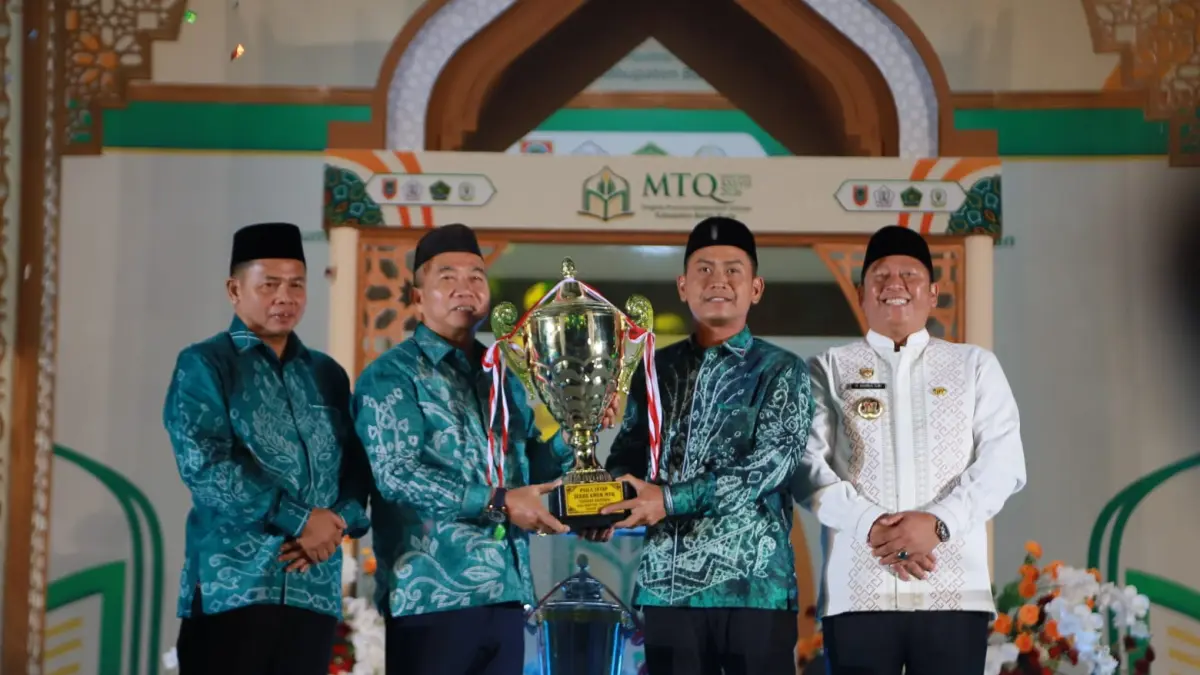 PENYERAHAN PIALA: Sekretaris Daerah Provinsi Kalimantan Selatan, H Muhammad Syarifuddin&nbsp;didampingi Bupati Barito Kuala, H Bahrul Ilmi menyerahkan piala bergilir kepada Wali Kota Banjarmasin HM Yamin yang mewakili selaku juara umum MTQN XXXVII Kalsel 2026 di Marabahan, Jumat (26/6/2026) malam.(Foto: Pemkab Batola)&nbsp;