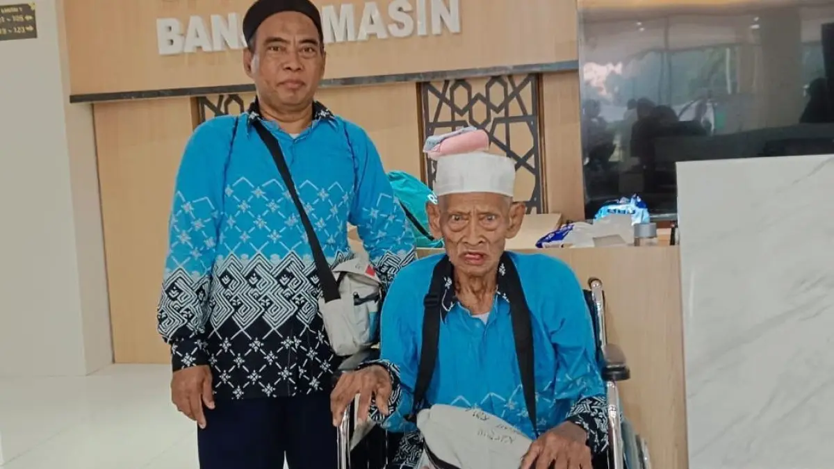 BAHAGIA: Sarmidin bersama sang ayah Kasrun saat ditemui petugas PPIH Banjarmasin di Asrama Debarkasi Banjarmasin. (Foto: HUMAS KEMENHAJ UNTUK RADAR BANJARMASIN)