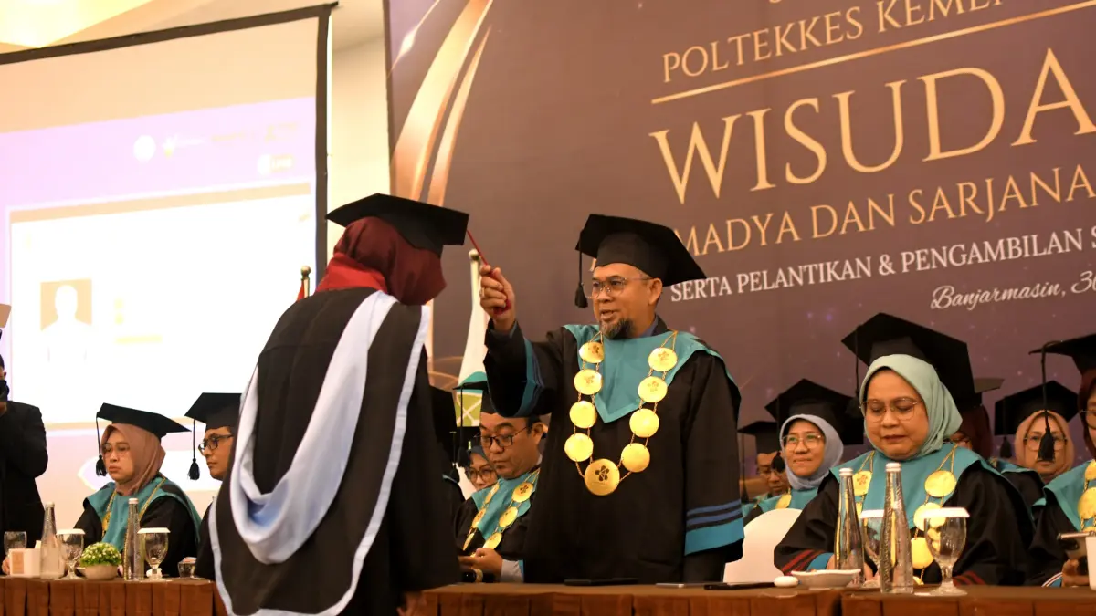 PEMINDAHAN TALI TOGA: Direktur Poltekkes Kemenkes Banjarmasin, Dr. H. Mars Khendra Kusfriyadi, STP., MPH, melakukan pemindahan tali toga kepada salah satu wisudawan sebagai tanda resmi kelulusan pada Wisuda ke-38 Poltekkes Kemenkes Banjarmasin, Selasa (30/6/2026).