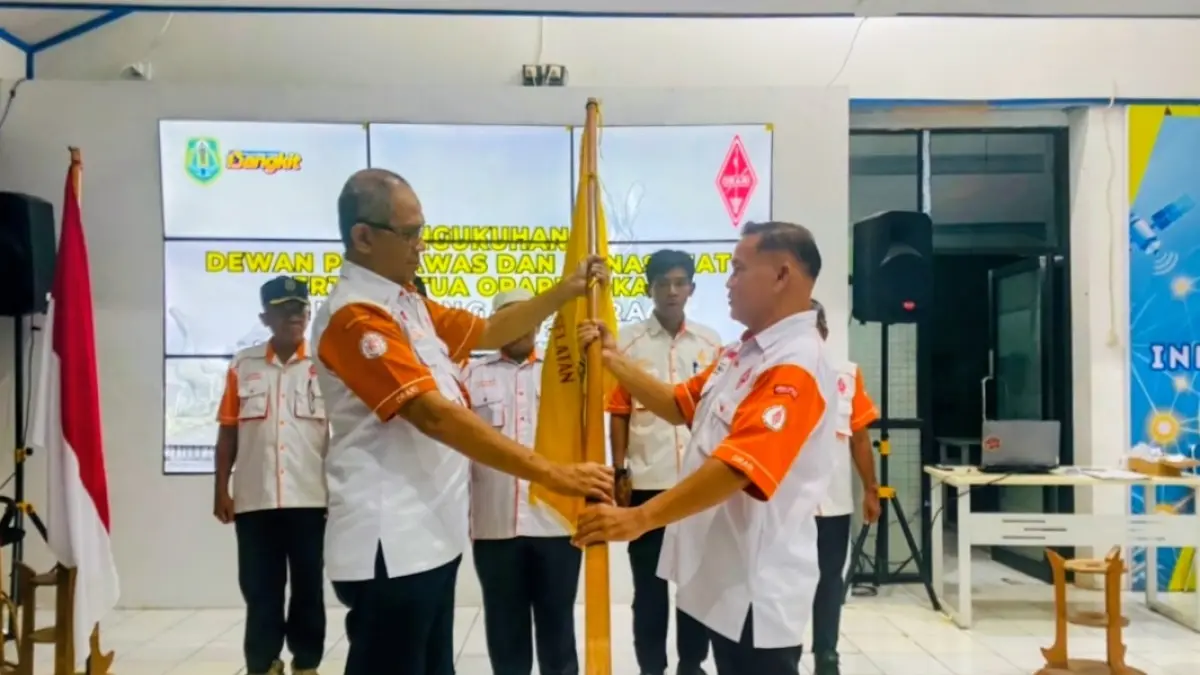 Budiansyah (kanan) menerima pataka usai terpilih sebagai Ketua ORARI Lokal Hulu Sungai Utara periode 2026–2029 melalui Muslok ke-13 di Gedung Kominfo Amuntai. (ORARI HSU)