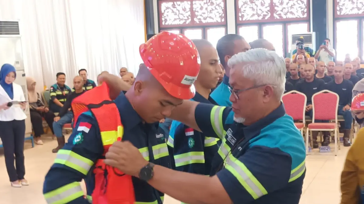 SIAP BEKERJA: Bupati Kabupaten Tabalong, Muhammad Noor Rifani memasangkan helm secara simbolis kepada salah satu remaja yang diterima bekerja di PT SIS sebagai operator alat berat.
