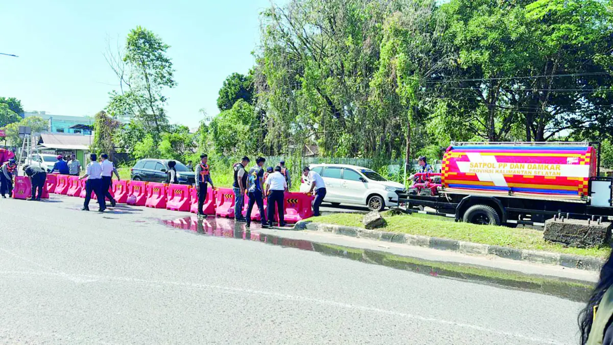 DITUTUP: Petugas saat menutup u-turn di Jalan Angkasa, Kelurahan Syamsudin Noor menggunakan water barier.
(Foto: Sheilla/Radar Banjarmasin)