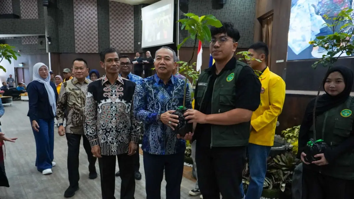PRODUKITF: Sekdaprov Kalsel HM Syarifuddin menyerahkan bibit pohon produktif secara simbolis kepada perwakilan mahasiswa KKN sebagai bentuk komitmen ULM mendukung pelestarian lingkungan.