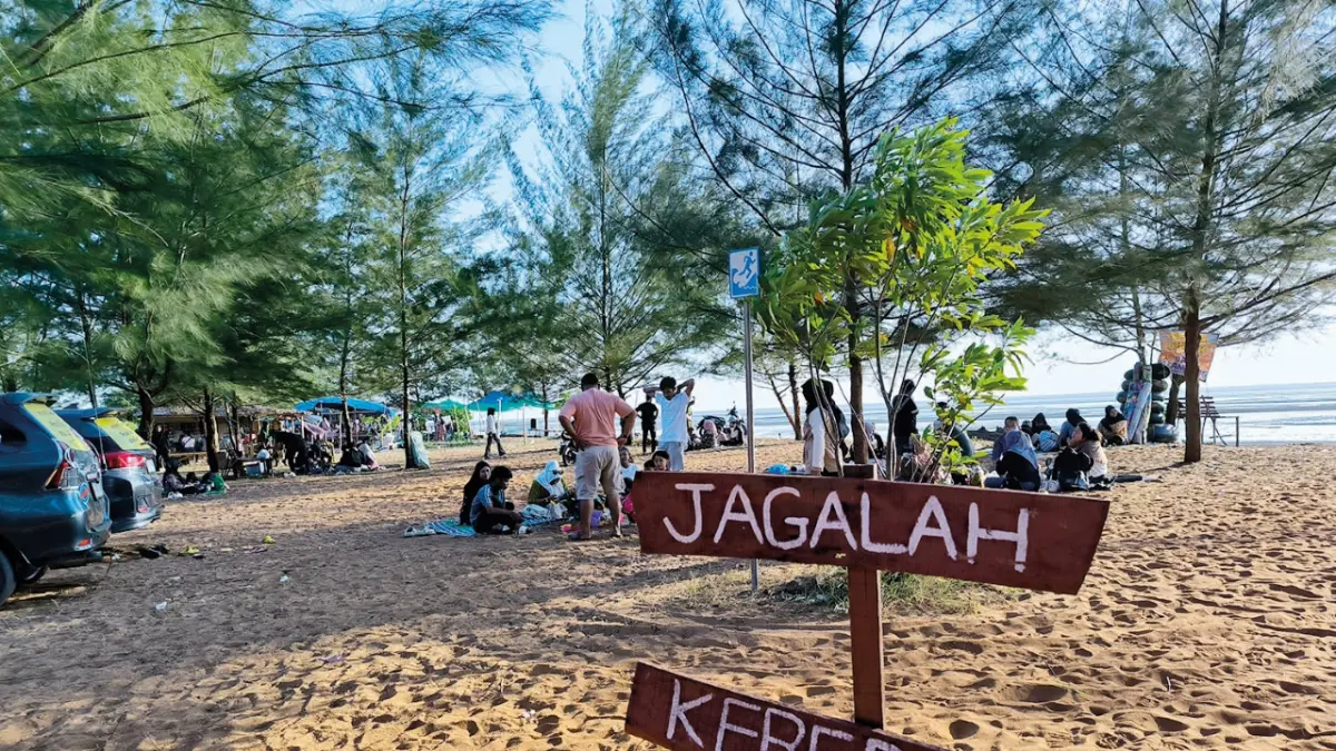 Teduh: Sejumlah pelancong sedang menikmati rimbunnya pohon cemara yang berada di sepanjang Pantai Kasuari