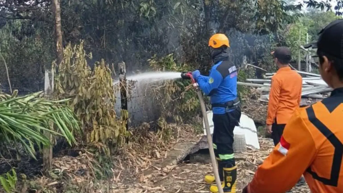 KARHUTLA: Anggota BPBD Tapin melakukan pemadaman api di semak belukar di kawasan Kompleks Cahaya Fajar Regency 2 dan 3, Kelurahan Rangda Malingkung RT 16, Kecamatan Tapin Utara, Senin (13/7/2026) siang.