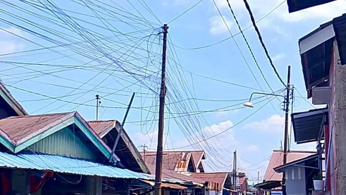 Warga Gang Laila RT 10, Kelurahan Murung Raya mengeluhkan kabel listrik dan fiber optik yang semrawut hingga membahayakan keselamatan.(Endang Syarifuddin/Radar Banjarmasin)