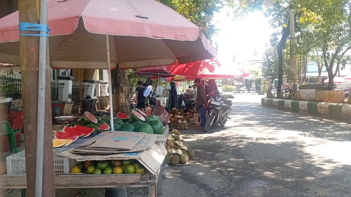 BERJUALAN: Aktivitas pedagang buah musiman yang berjualan di bahu jalan pusat Kota Kandangan. (Foto: M. Padil Ihsan/Radar Banjarmasin)&nbsp;