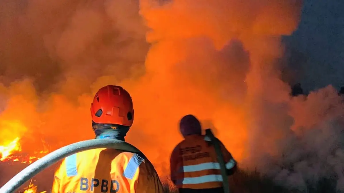 PEMADAMAN: Petugas BPBD Banjarbaru memadamkan kebakaran hutan dan lahan hingga malam untuk mencegah api meluas ke permukiman warga. (Foto: BPBD Banjarbaru)
