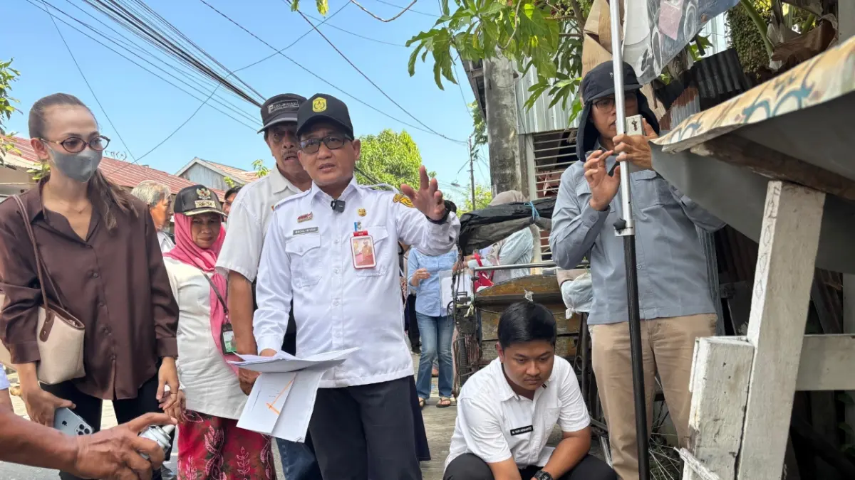 DI LAPANGAN: Mediator Kota Banjarmasin, Machli Riyadi memimpin pengukuran batas tanah berdasarkan seluruh dokumen kepemilikan terhadap sengketa yang selama ini melibatkan warga di Kompleks DPR, Gang 6, Banjarmasin Barat. (Foto: Zulvan Rahmatan/Radar Banjarmasin)