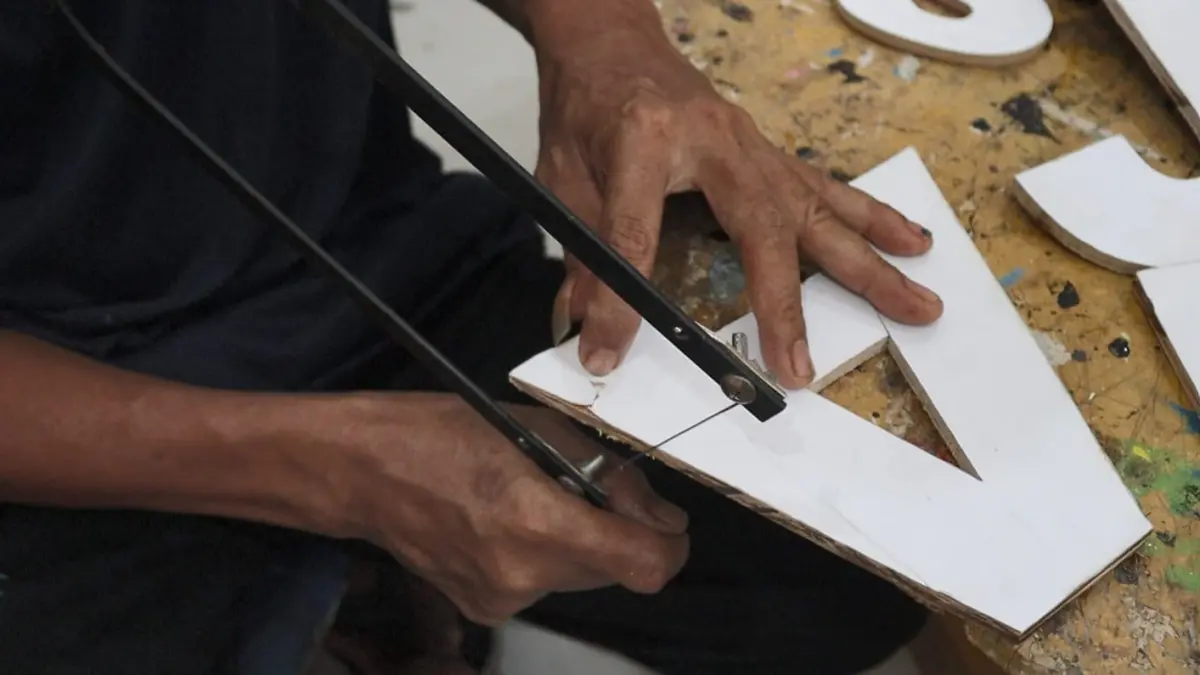TERAMPIL: Warga binaan Lapas Kelas III Batulicin membuat kerajinan huruf timbul berbahan triplek secara manual sebagai bagian dari program pembinaan kemandirian. (Foto: Lapas Batulicin)