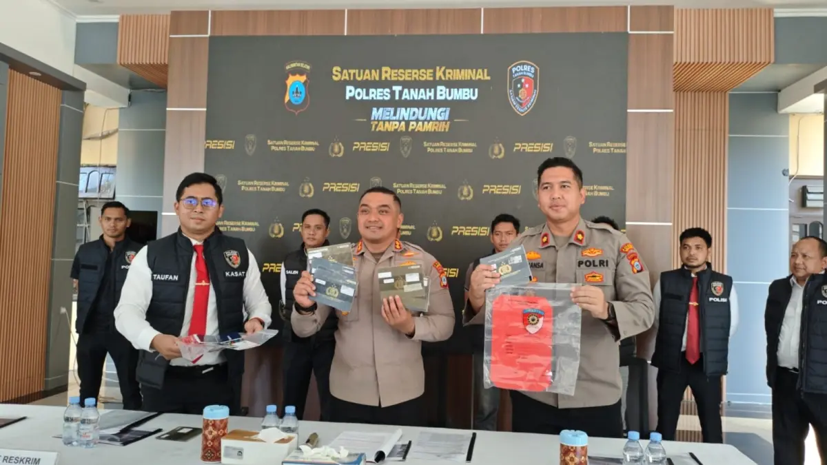 Kapolres Tanah Bumbu, AKBP Novy Adi Wibowo (kanan) didampingi Kasat Reskrim, AKP Taufan Maulana (kiri) menunjukkan barang bukti BPKB palsu saat rilis kasus, Senin (20/7). (Zulqarnain/Radar Banjarmasin)&nbsp;