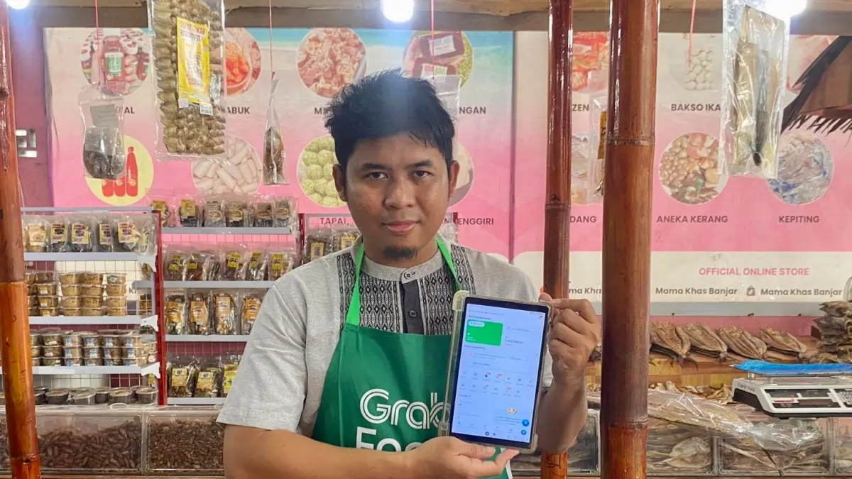 MAKIN MAJU: Firli Norachim, pemilik Toko Mama Khas Banjar di Banjarmasin mengembangkan usaha oleh-oleh khas Banjar dengan memaksimalkan layanan digital, mulai dari pembayaran QRIS OVO, hingga akses pendanaan GrabModal by OVO Finansial untuk mendukung pengembangan produk dan usaha.

&nbsp;