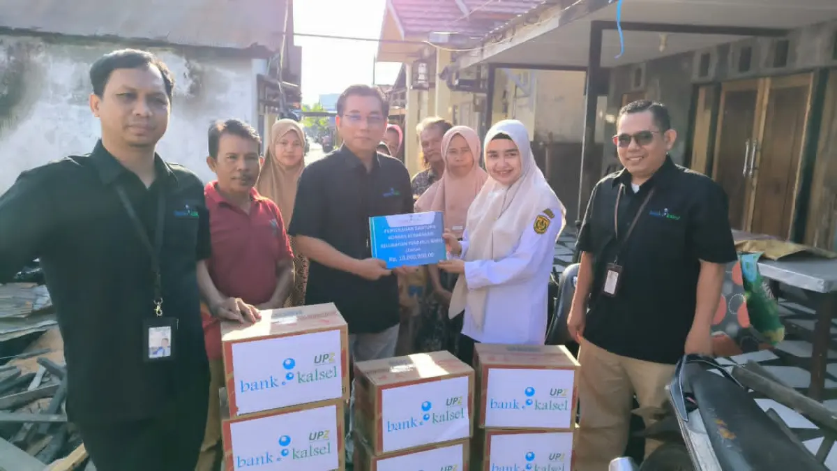 BANTUAN: Kepala Cabang Utama Bank Kalsel, Rudy Fahrurrazi saat penyerahan bantuan untuk korban kebakaran di Gang Kasturi dan Gang Jambu.