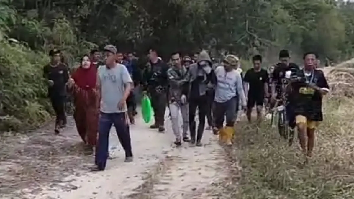 BERJALAN: Harianto (29) dibantu para relawan saat dievakuasi setelah ditemukan selamat usai hilang sekitar 25 jam di kawasan hutan Desa Salam Babaris, Kecamatan Salam Babaris, Kabupaten Tapin, Rabu (22/7/2026). (Foto: Relawan/Radar Banjarmasin)