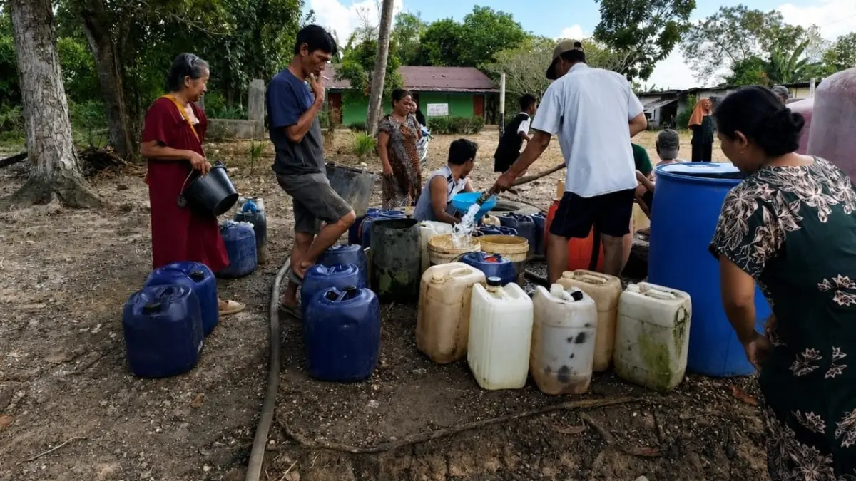 DAMPAK KEKERINGAN: Warga menampung air bersih yang disalurkan menggunakan mobil tangki di Desa Bawahan Selan, Kecamatan Mataraman yang terdampak kekeringan di Kabupaten Banjar, Minggu (19/7). (BPBD BANJAR)