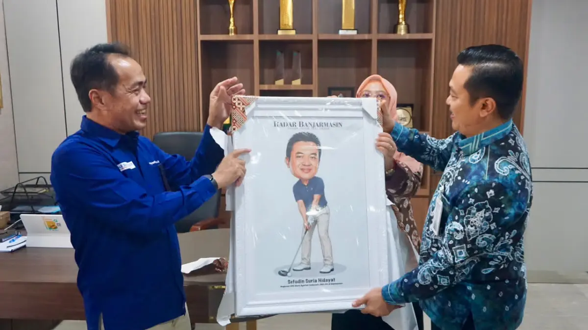 KARIKATUR: Kepala RCEO BSI Region IX Kalimantan, Sefudin Suria Hidayat membuka bingkisan yang diserahkan oleh Direktur Utama Radar Banjarmasin H Suriansyah Achmad.&nbsp;