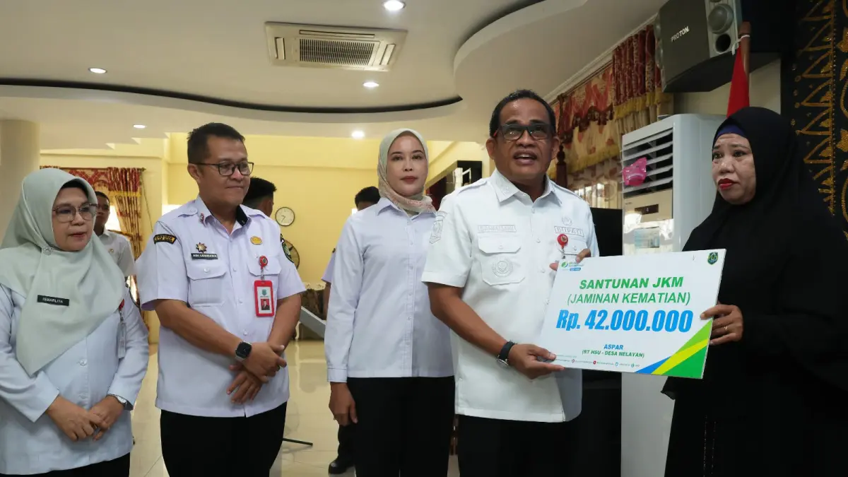 PROGRAM: Bupati HSU, H Sahrujani menyerahkan kartu kepesertaan BPJS Ketenagakerjaan secara simbolis kepada perwakilan pekerja rentan pada peluncuran program perlindungan sosial ketenagakerjaan di Amuntai, Rabu (22/7/2026). (Foto: Pemkab HSU)