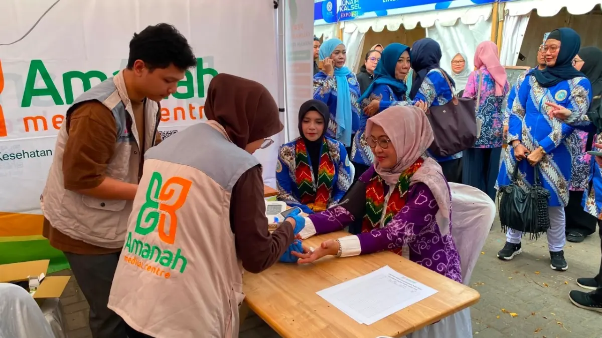 Ketua IKA Unair Kalsel, drg. Ellyana Trisya Hasnuryadi, mencoba pemeriksaan kesehatan di salah satu stand saat pembukaan IKA Unair Kalsel Great Expo 2026 di Siring Menara Pandang, Banjarmasin, Jumat (24/7). (Hesti untuk Radar Banjarmasin)