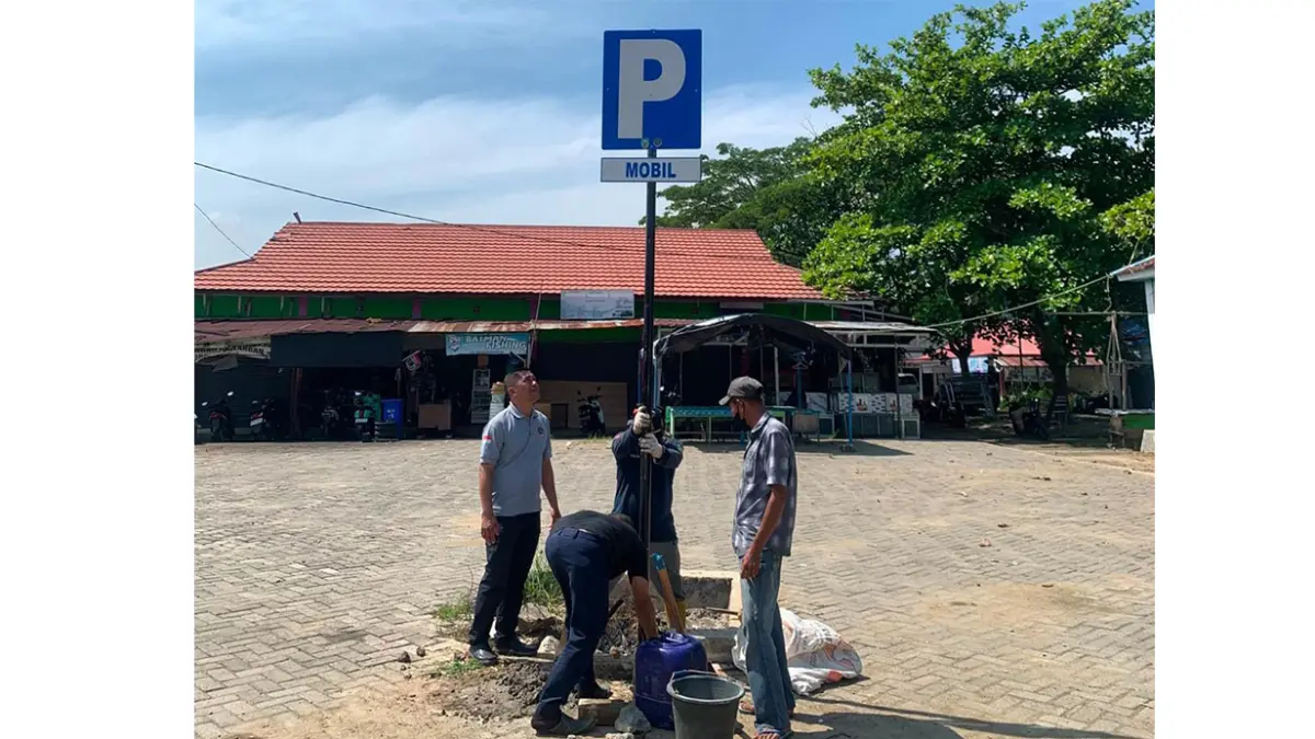 PENERTIBAN FASILITAS PUBLIK: Petugas Dinas Perhubungan Kabupaten Balangan saat memasang rambu parkir resmi di kawasan Pasar Batumandi guna mengurai potensi kemacetan akibat parkir sembarangan.