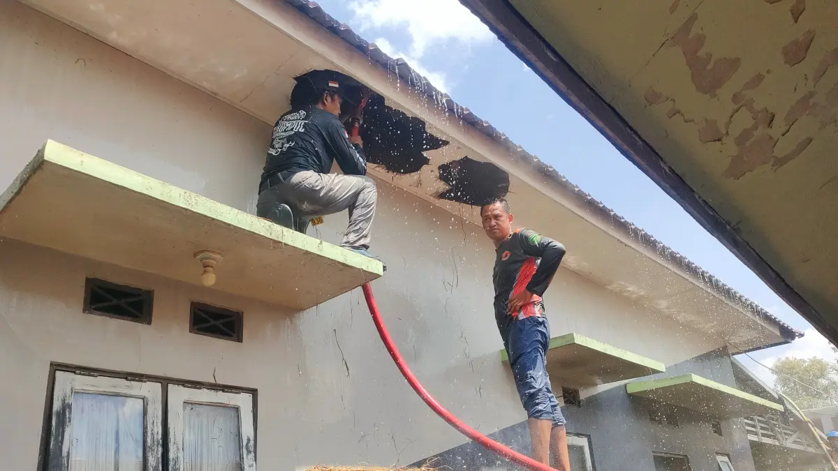 PADAMKAN: Petugas gabungan berjibaku memadamkan api yang berkobar di sebuah rumah warga. (Foto: Pusdalops BPBD Tapin)&nbsp;