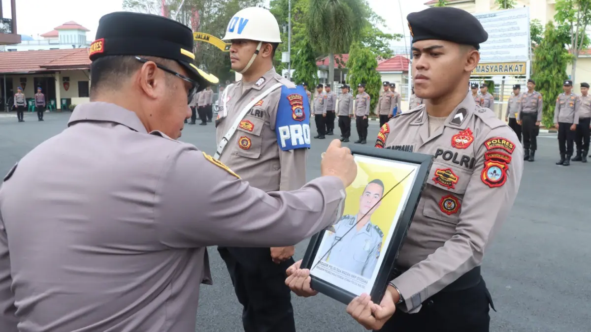 DICORET: Kapolres HSU AKBP Agus Nuryanto menyilang tanda X pada foto anggota Polres HSU yang di PTDH di halaman Polres HSU.