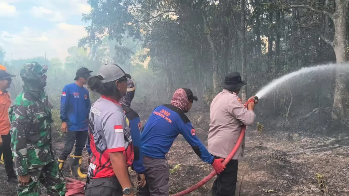 Petugas gabungan memadamkan api yang membakar semak belukar di Kecamatan Tapin Utara. (Pusdalops BPBD Tapin)