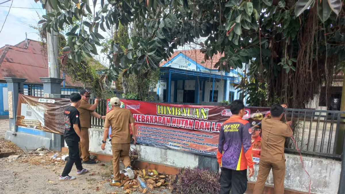 SPANDUK PERINGATAN: Petugas BPBD Balangan memasang spanduk larangan membakar lahan di kawasan strategis kecamatan guna mencegah meluasnya titik api. (El untuk Radar Banjarmasin)