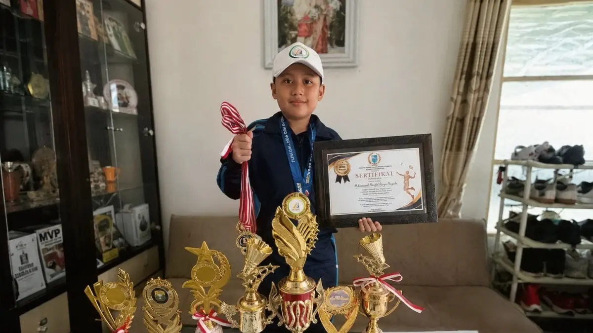 TEGAR: Muhammad Naufal Razqa Prayuda memperlihatkan koleksi piala dan medali hasil berbagai kejuaraan yang diraihnya. Meski gagal tampil di O2SN tingkat nasional, atlet muda asal Kabupaten Banjar itu tetap bertekad melanjutkan latihan. (Dok Radar Banjarmasin)