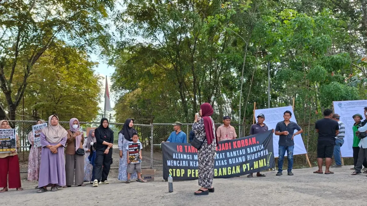 AKSI: Puluhan warga menggelar aksi damai di depan gerbang PT Merge Mining Industri (MMI) di Desa Rantau Bakula, Kecamatan Sungai Pinang, Kamis (30/7/2026), menuntut penghentian operasional perusahaan setelah dijatuhi sanksi administratif terkait dugaan pelanggaran lingkungan. (Foto: WALHI Kalsel)