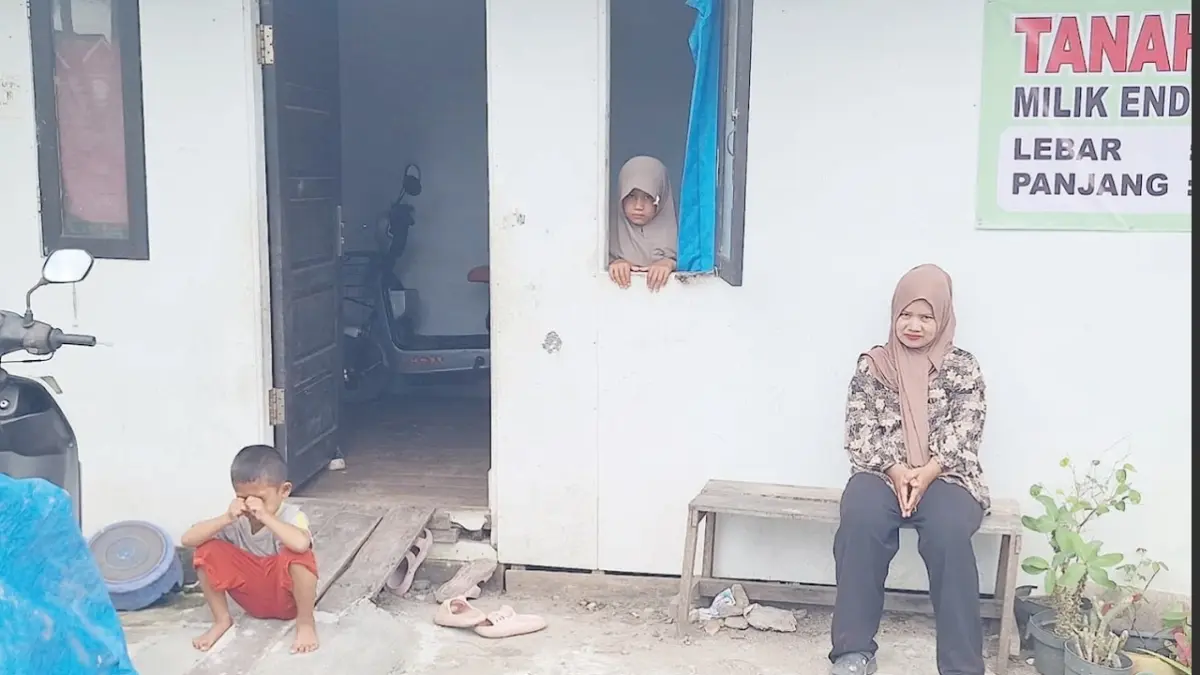 TERANCAM: Nana (32), warga Tambak Langsat, Kelurahan Syamsudin Noor, Kecamatan Landasan Ulin bersama kedua anaknya saat berada di rumahnya yang terancam digusur.&nbsp;

(SHEILLA FARAZELA/RADAR BANJARMASIN)&nbsp;