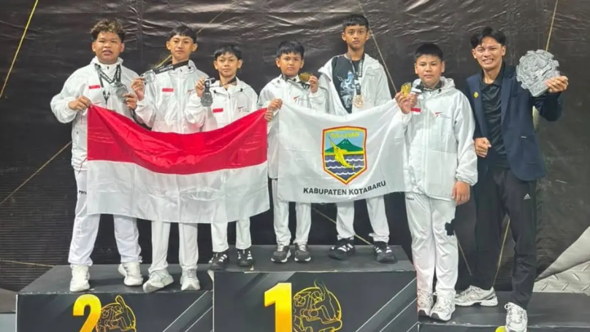 MEMBANGGAKAN: Enam atlet Taekwondo Kotabaru berfoto bersama pelatih di atas podium sambil mengibarkan bendera Merah Putih dan bendera Kabupaten Kotabaru. (Foto: KONI Kotabaru untuk Radar Banjarmasin)&nbsp;