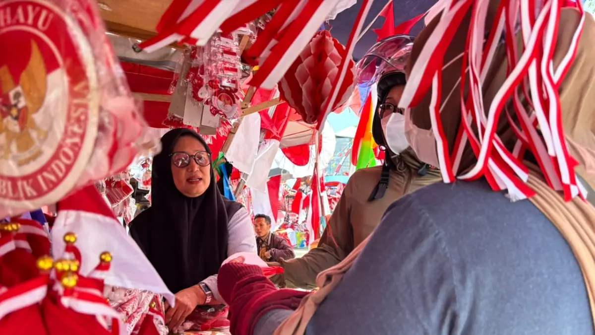 MUSIMAN: Rita salah satu pedagang bendera di Kawasan Taman Sari, Banjarmasin Tengah manfaatkan momen musiman menjelang Hari Kemerdekaan. 