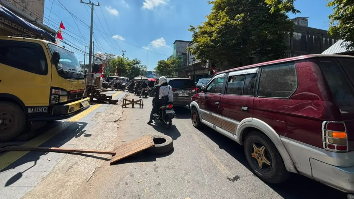 MENGULAR: Antrean panjang di SPBU Jalan Martadinata, Banjarmasin Barat membuat warga resah karena akses keluar masuk mereka kerap terhalangi. (Foto: Zulvan Rahmatan/Radar Banjarmasin)
