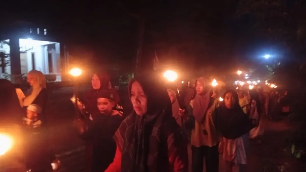 PAWAI: Warga Desa Jelatang membawa obor sambil melantunkan salawat Burdah dalam menyambut Arba Mustamir, Selasa malam (11/8/2026). (Foto: M Padil Ihsan/Radar Banjarmasin)
